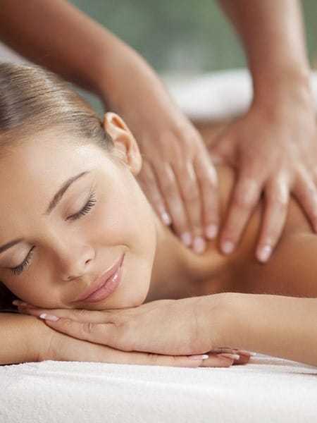 A woman enjoys a relaxing back massage at a spa session.