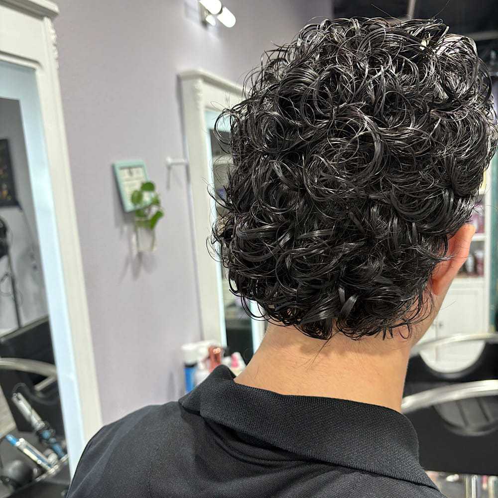 Curly hairstyle from the back in a modern salon setting.
